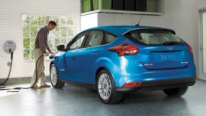 Homem recarregando o seu Ford Focus Azul na garagem de casa